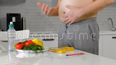 肥胖男子测量他的腰部，健康饮食，健康的生活方式观念，健身饮食